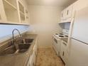 Functional kitchen with white appliances, double sink, and light colored cabinets at 9650 Huron St # 23, Thornton, CO 80260