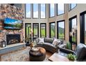 Sun-drenched living room featuring a stone fireplace and mountain views at 1194 Snyder Mountain Rd, Evergreen, CO 80439