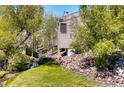 Tan siding townhouse exterior with a creek and green space at 6700 W 11Th Ave # 205, Lakewood, CO 80214