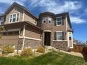 Inviting home exterior showcasing the stone-accented entrance and well-maintained lawn at 14193 Double Dutch Cir, Parker, CO 80134