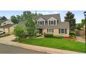 Beautifully landscaped front yard featuring a well-maintained lawn and attractive brick facade at 8896 W Prentice Ave, Littleton, CO 80123