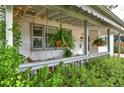Relaxing front porch with hanging ferns and comfortable seating under ambient string lights at 2083 W Arbor Ave, Littleton, CO 80120