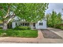 Attractive home features a well-maintained lawn, lush tree, and welcoming front porch at 2083 W Arbor Ave, Littleton, CO 80120