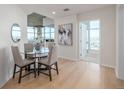 Bright dining area with a glass table and seating for four, adjacent to the living room and a view of the city at 1700 Bassett St # 1106, Denver, CO 80202
