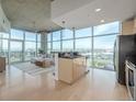 Open-concept kitchen and living area with hardwood floors and expansive windows offering city views at 1700 Bassett St # 1106, Denver, CO 80202