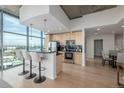 Modern kitchen with stainless steel appliances, granite countertops, breakfast bar, and scenic city views at 1700 Bassett St # 1106, Denver, CO 80202
