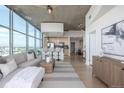 Bright living room with light wood floors, floor to ceiling windows and partial kitchen view at 1700 Bassett St # 1106, Denver, CO 80202