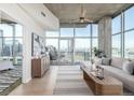 Bright living room with city views from floor-to-ceiling windows, complemented by a comfortable seating area and a neutral color palette at 1700 Bassett St # 1106, Denver, CO 80202
