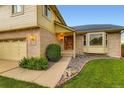 Home exterior featuring brick accents, a bay window, and a well-kept lawn at 9670 W 70Th Ave, Arvada, CO 80004