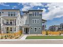 Attractive three-story home with blue siding and a charming wooden fence under a sunny, partly cloudy sky at 11000 Shining Star Cir, Parker, CO 80134