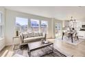 Bright, open-concept living room with hardwood floors and an adjacent kitchen area at 1138 W 84Th Pl, Denver, CO 80260