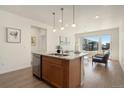 Kitchen island with stainless steel dishwasher, and stainless steel sink at 6153 N Ceylon St # 203, Denver, CO 80249