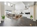 Open-concept living room and kitchen boasts high ceilings, modern furnishings, and lots of natural light at 5566 Hickory Oaks Trl, Castle Rock, CO 80104