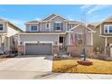 Charming two-story home featuring a brick-accented facade, manicured lawn, and an attached two-car garage at 2538 Ambience Ln, Castle Rock, CO 80109