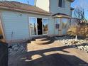 Back patio featuring stone pavers and steps leading to sliding glass doors, providing a seamless transition to indoor living at 6044 S Yakima St, Aurora, CO 80015