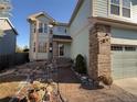 Inviting front entrance with walkway, rock landscaping, and brick accents leading to the front door and attached garage at 6044 S Yakima St, Aurora, CO 80015