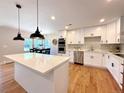 Bright kitchen featuring a quartz island, stainless appliances, modern lighting, and eat in dining area at 9451 E Evans Pl, Denver, CO 80231