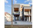 Modern townhomes with recessed balconies and sleek architectural details under a bright sky at 2330 Eliot St # 1, Denver, CO 80211