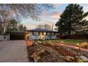Attractive home with a well-maintained lawn, brick accents, and mature trees at 6402 E Cornell Ave, Denver, CO 80222