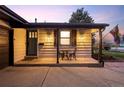 Inviting front porch with seating area and decorative lighting at 6402 E Cornell Ave, Denver, CO 80222