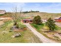 Charming ranch-style home with a long driveway and well-maintained lawn and mature trees at 12101 Riverdale Rd, Brighton, CO 80602