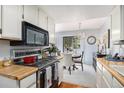 Efficient kitchen leading to dining area with white cabinets and modern appliances at 60 S Moline St, Aurora, CO 80012