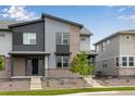 Modern townhome featuring a stylish gray facade with brick accents and a well-maintained front yard at 1418 Hudson Pl, Longmont, CO 80501