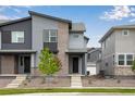 Modern townhome featuring a stylish gray facade with brick accents and a well-maintained front yard at 1418 Hudson Pl, Longmont, CO 80501
