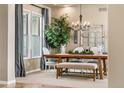 Bright dining area featuring hardwood floors, stylish lighting, and large windows with backyard views at 6303 Ellingwood Point Pl, Castle Rock, CO 80108