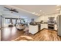 Modern kitchen with white cabinets, stainless steel appliances, and hardwood floors at 6995 S Ash Cir, Centennial, CO 80122