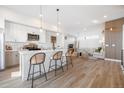 Open floor plan with modern kitchen, island with bar stool seating, and living room, creating an inviting space at 2920 W Parkside Pl, Denver, CO 80221