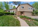Charming two-story home with brick accents, manicured lawn, mature trees, and a two car garage at 6621 E Peakview Pl, Centennial, CO 80111
