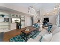 Spacious living room featuring built-in shelving, lots of seating, wood floors, and access to the upstairs at 6621 E Peakview Pl, Centennial, CO 80111