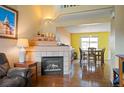 Inviting living room with a fireplace, hardwood floors, and an open view to the dining area at 11207 Day Star Ct, Parker, CO 80138
