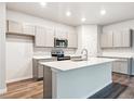 Modern kitchen with gray cabinets, quartz countertops, stainless steel appliances, and large island at 19019 E 94Th Pl, Commerce City, CO 80022