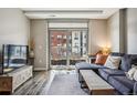 Relaxing living room with balcony access, stylish furnishings, wood-look floors, and plenty of natural light at 4200 W 17Th Ave # 327, Denver, CO 80204