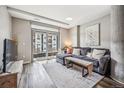 Bright living room featuring a comfy gray couch and a balcony with city views at 4200 W 17Th Ave # 327, Denver, CO 80204