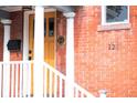Close up of the entrance, featuring a wooden door, porch, and brick exterior at 120 Cherokee St, Denver, CO 80223