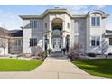 Elegant home exterior with an arched entryway, stately columns, and manicured landscaping at 1185 W 140Th Dr, Westminster, CO 80023