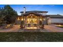 Covered patio with fire pit, comfortable seating, and stone pillars overlooking backyard at 6111 Huron Pl, Castle Rock, CO 80108