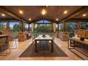 Elegant covered patio with wood ceiling, stone accents, dining area, and outdoor kitchen at 6111 Huron Pl, Castle Rock, CO 80108