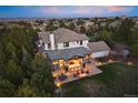 Spacious backyard with covered patio, outdoor seating, fire pit, and lush greenery at 6111 Huron Pl, Castle Rock, CO 80108