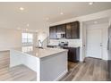 Contemporary kitchen with a white kitchen island, dark cabinets, and stainless steel appliances at 11039 Snowdon St, Parker, CO 80134