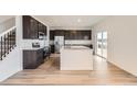 Modern kitchen with dark cabinets, stainless steel appliances, a kitchen island, and a sliding glass door at 11039 Snowdon St, Parker, CO 80134