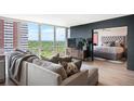 Open living room with expansive windows showcasing the city view and access to the adjacent bedroom at 3100 E Cherry Creek South Dr # 1403, Denver, CO 80209