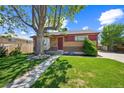 Charming brick home with a well-manicured lawn and mature shade tree at 7820 Tejon St, Denver, CO 80221