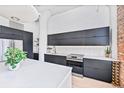 Modern kitchen with sleek dark cabinets, stainless steel appliances, and a bright white countertop island at 2000 Arapahoe St # 503, Denver, CO 80205