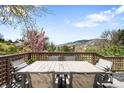 Relaxing deck with outdoor dining table set surrounded by lush greenery and mountain views at 600 Cascade Dr, Golden, CO 80403