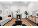 Bright living room with a decorative fireplace, plush white sofa, and stylish accents on hardwood floors at 8814 S Winnipeg Ct, Aurora, CO 80016