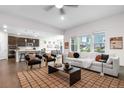 Open-concept living space features hardwood floors, bright windows, a modern kitchen, and comfortable seating at 8814 S Winnipeg Ct, Aurora, CO 80016